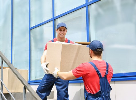 Professional house removalists loading boxes in a London residential street