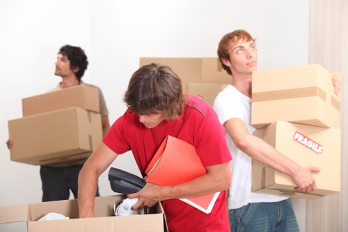 Professional movers handling furniture in a London flat with narrow access